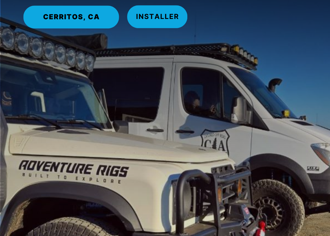 Two off-road vehicles with 'Adventure Rigs' branding on a dirt road.